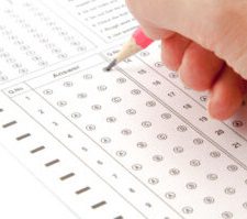 A hand is holding a pencil and writing on a sheet of paper.