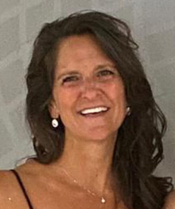 Smiling woman with dark hair and earrings.